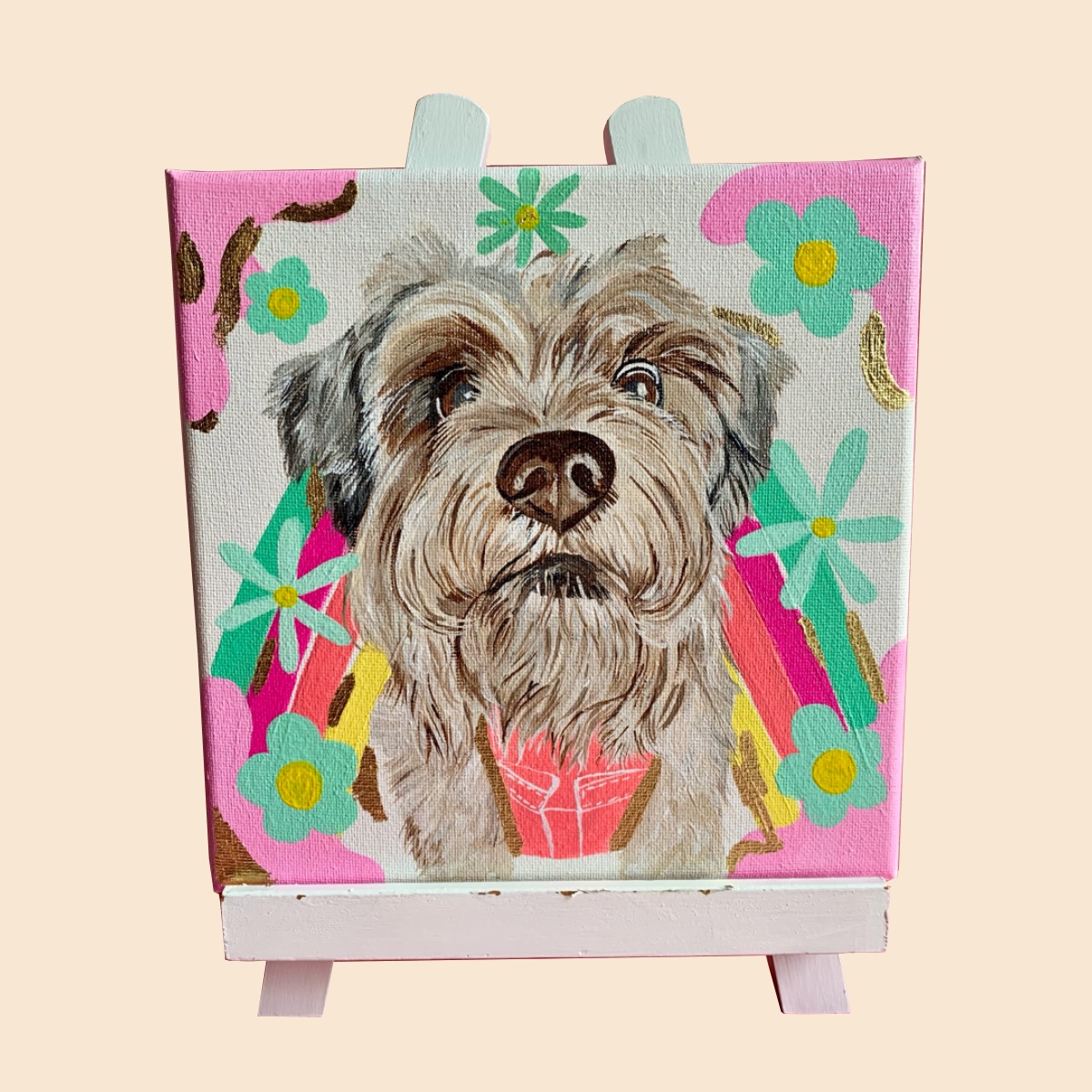 Mini canvas on an easel with a custom dog portrait and colorful flowers.